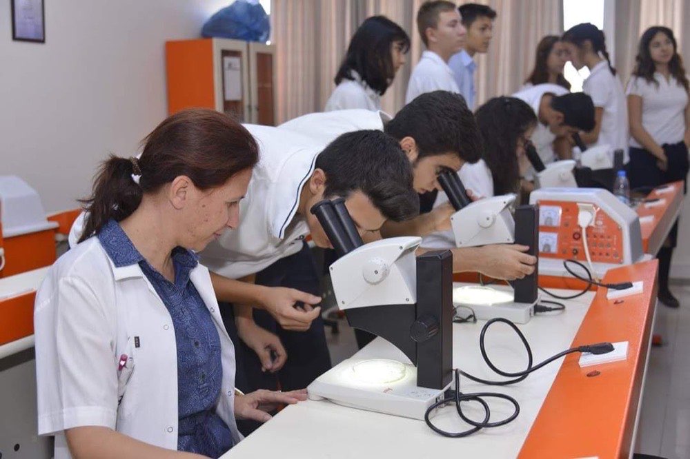 Kamp öğrencileri fizik laboratuvarında deney istasyonlarında